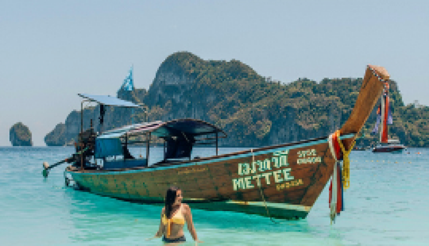 Boat in Bucht in Asien mit türkisem Wasser in Thailand.